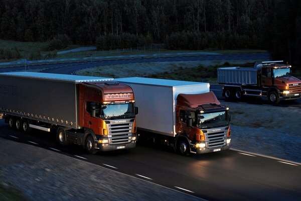 Trois camions roulent sur les routes de nuit