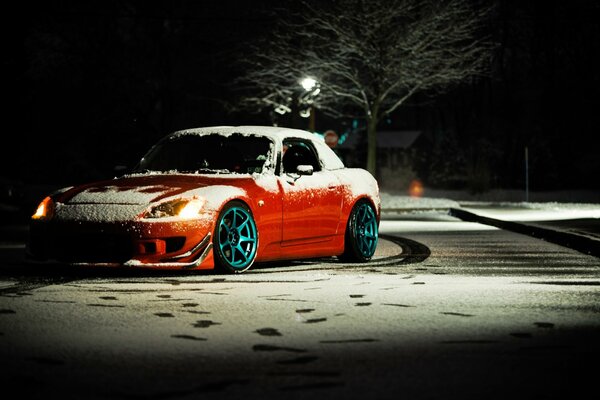 Honda S2000 naranja en una calle cubierta de nieve