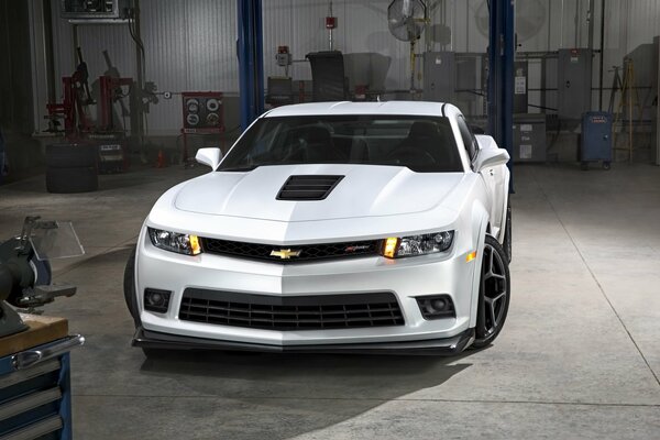 White Camaro close-up in a car repair shop