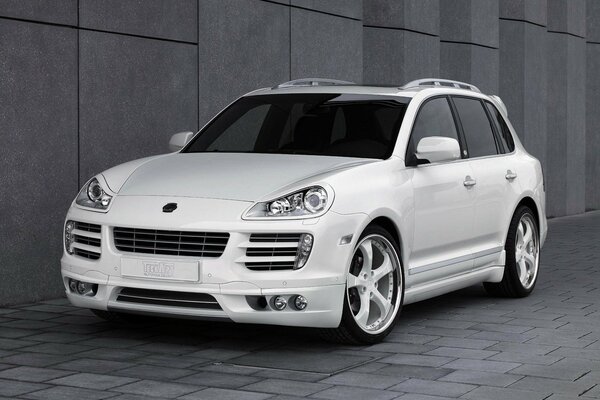 Weißer Porsche Cayenne auf grauem Hintergrund