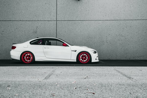 Voiture blanche BMW m3 sur fond de mur