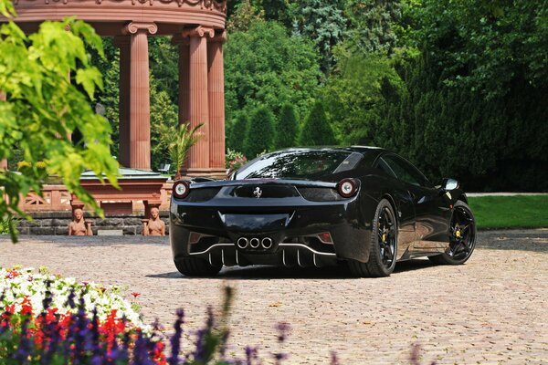 El coche negro de Ferrari está parado en el Jardín