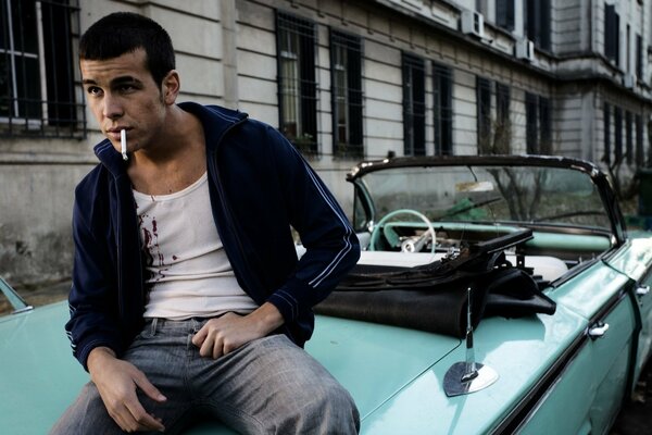 L acteur Mario Casas est assis et fume en voiture