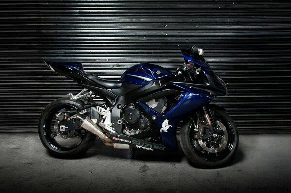 A blue motorcycle stands on a gray background