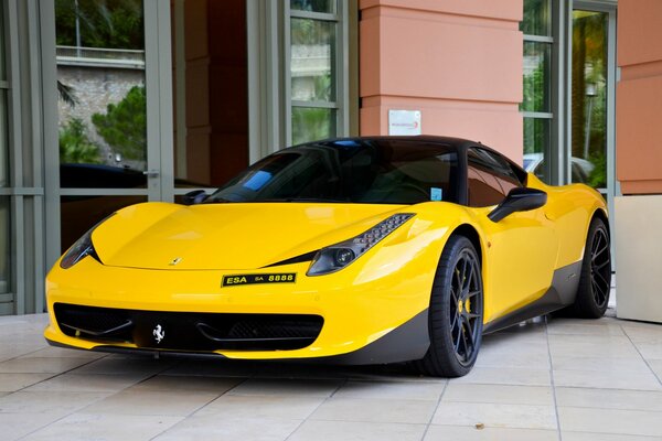 Yellow Ferrari on the background of the facade of the building