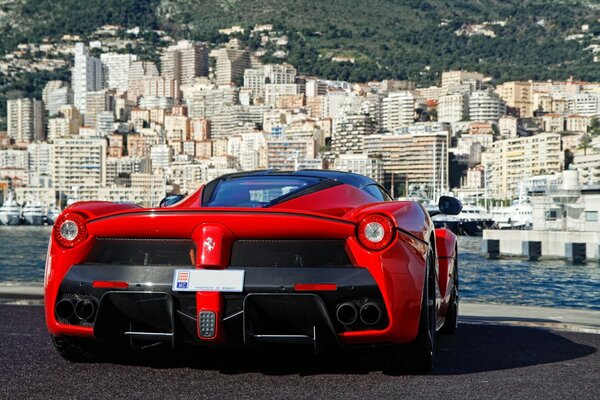 Red Ferrari on the background of a big city