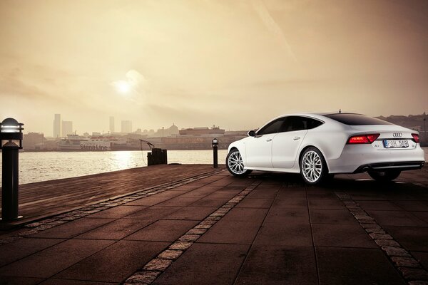 Silver Audi A7 car on the river embankment