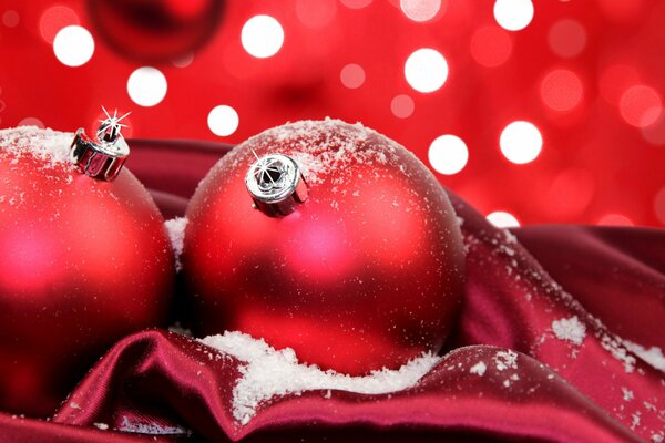 Bolas de Navidad rojas en la nieve en tela roja