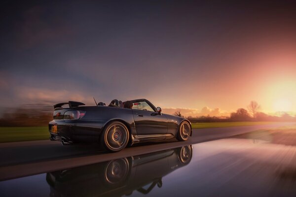 Ein schönes Auto, das bei Sonnenuntergang auf der Autobahn fährt