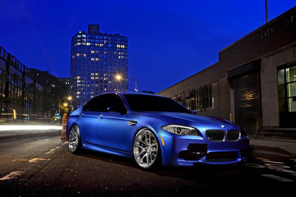 Night blue BMW is on the road in the city