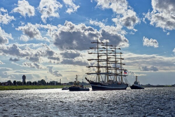 Sailing ship at sea against the background of clouds