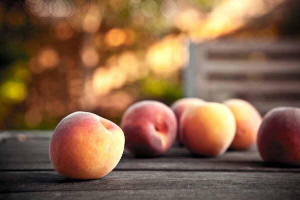 Peaches on a wooden table in the autumn garden