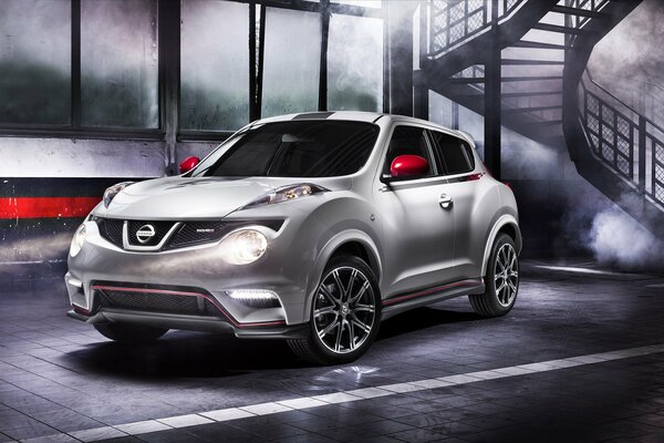 Weißer Nissan juke Nismo auf Treppen- und Rauchhintergrund