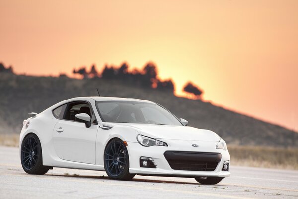 Subaru white on asphalt in the evening