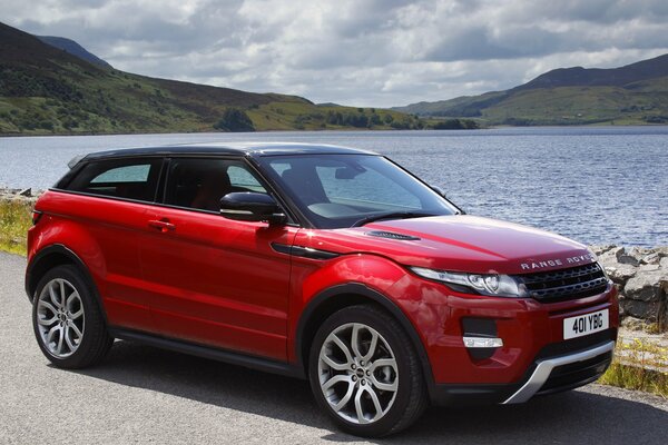 Auto rossa Land Rover sulla riva del Lago