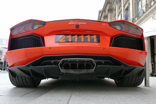 Rear view of an orange Lamborghini with a powerful exhaust pipe