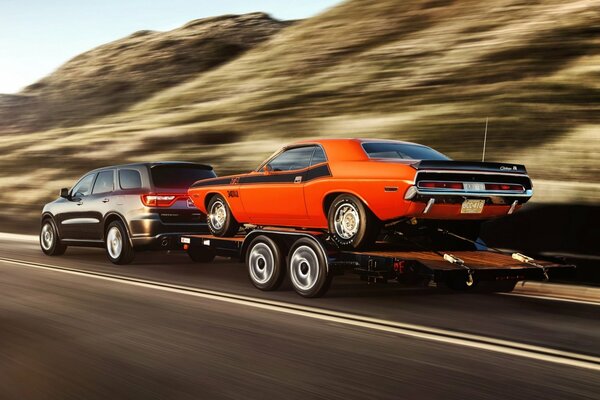 Challenger arrastra en un remolque Mustang