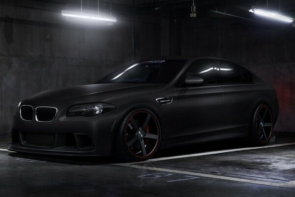 A black tuned boomer in an underground parking lot