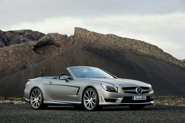 Voiture mercedes-benz sl 63 amg se dresse sur fond de montagne et de nuages