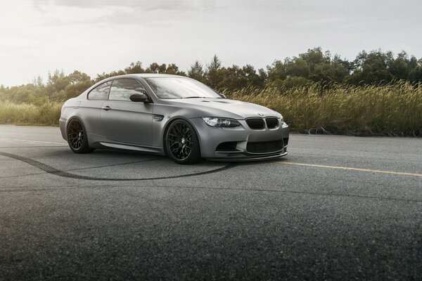 Grey BMW supercar on the road, wheel stripes