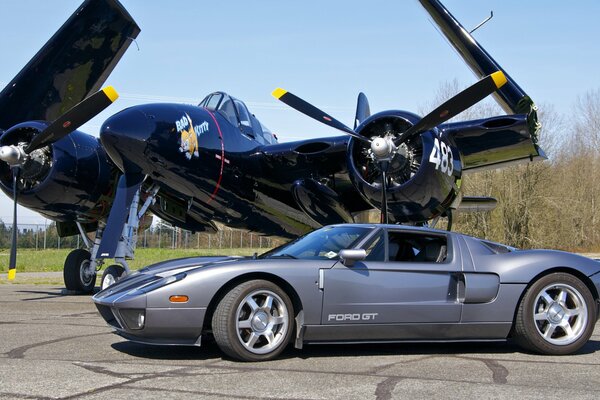 Grey supercar on the background of a fighter jet at the airfield