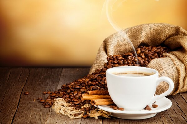 Coffee on a saucer against the background of coffee beans on the table