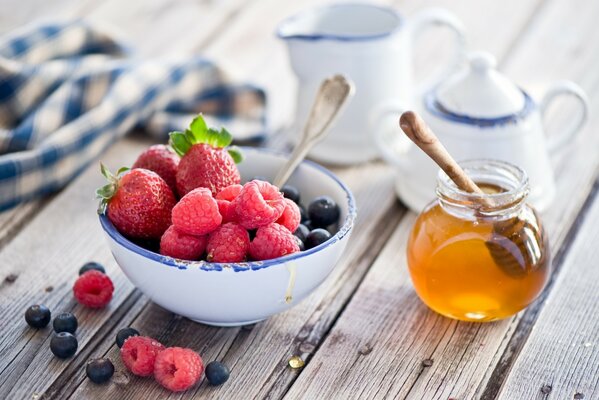 Strawberries and raspberries in a bowl on the table