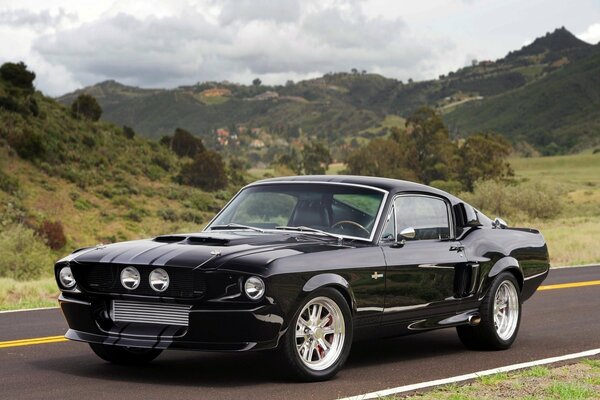 Black Ford Mustang on the background of mountains