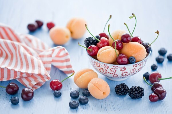 Baies et fruits dans une tasse debout sur la table