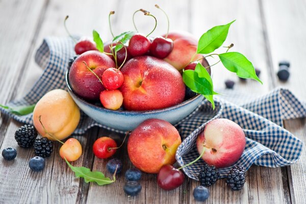 Bacche e frutta in una ciotola su un tavolo di legno