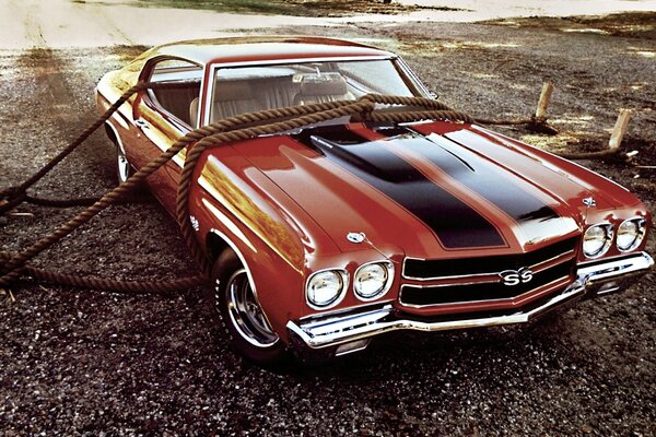 Red chevrolet ss hardtop. chevrolet coupe secured with ropes. front view