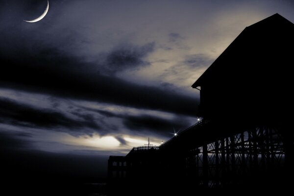 Maison sur la jetée la nuit au jeune mois