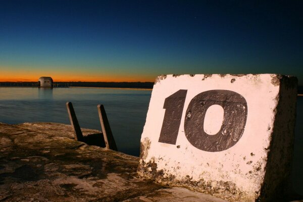 Imagen con un número en una piedra al atardecer