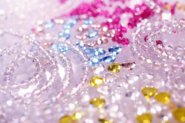 Rhinestones and beads lie on a pink background