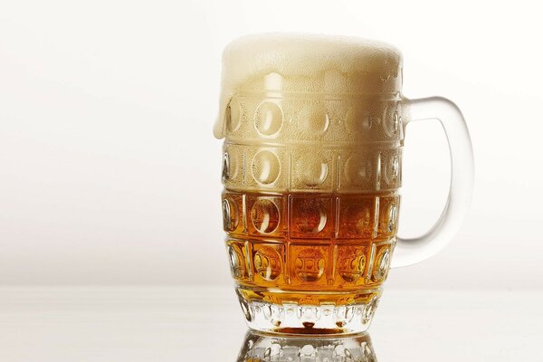 A mug half filled with beer, half with foam