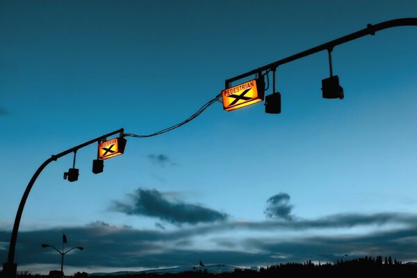 Signs on pillars above the evening sky