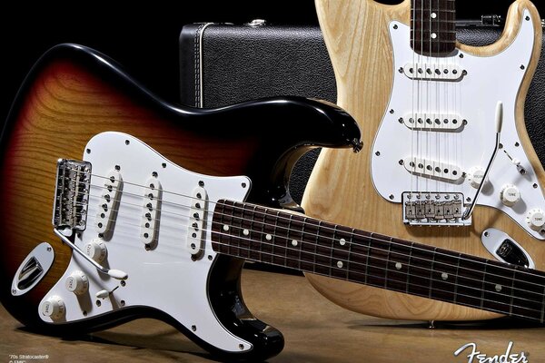 Two white fender guitars