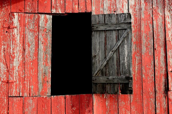 Fenster aus roten Brettern der alten Scheune