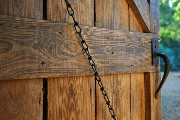 Wooden door with forged handle and chain