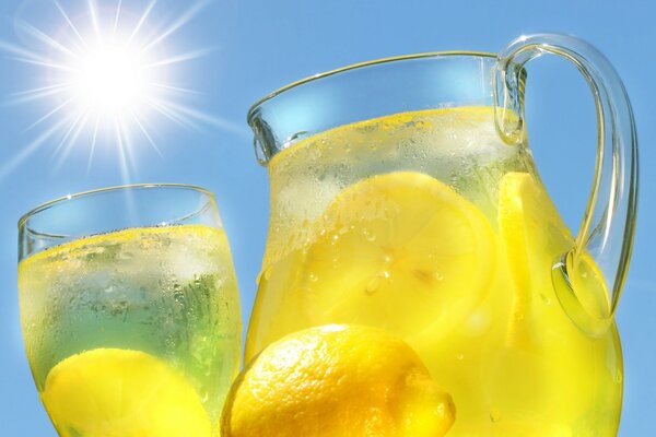 Limonade mit Zitrone in einem Krug vor dem Hintergrund der Sonne