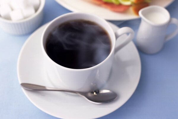 Eine Tasse duftenden Kaffee in einem weißen Becher auf dem Tisch