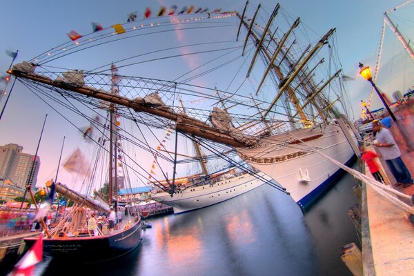 Yacht multicolori vicino al molo e persone