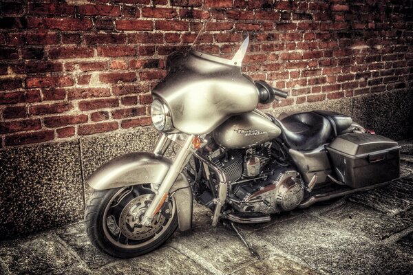 The legendary Harley is an unusual model of a motorcycle against a brick wall