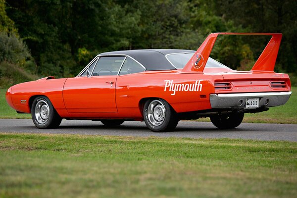 The red muscle car is on the road