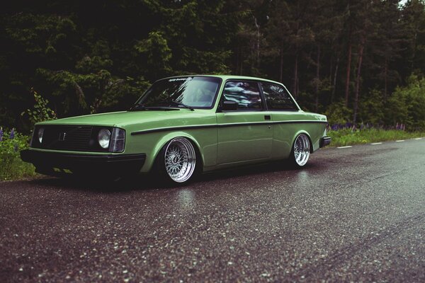 Green Volvo on a forest road