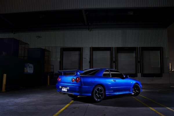 Voiture bleue nissan sort de l ombre