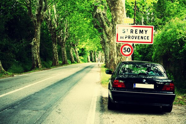 Bmw e38 on the side of the road in the woods