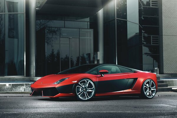 A red sports car is parked near the building