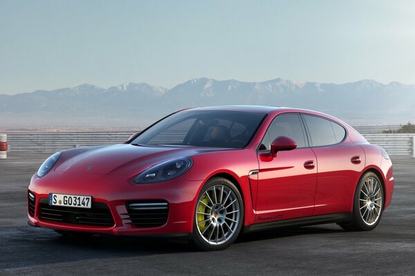 Red Porsche panamera on the background of mountains