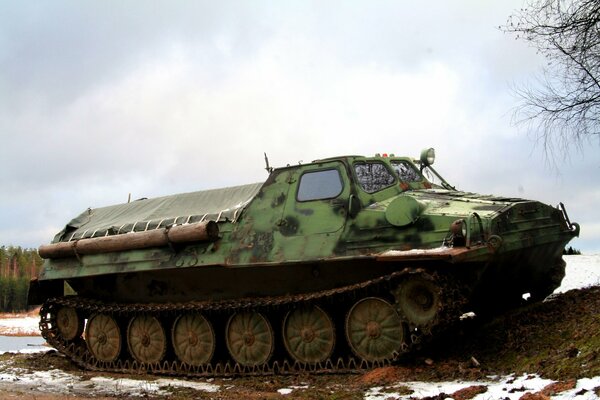 On a winter background, a tracked all-terrain vehicle